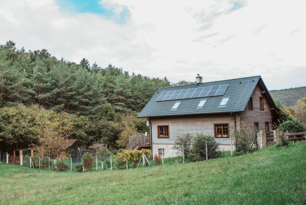 House with solar panels on roof. Alternative energy, saving resources and sustainable lifestyle concept.