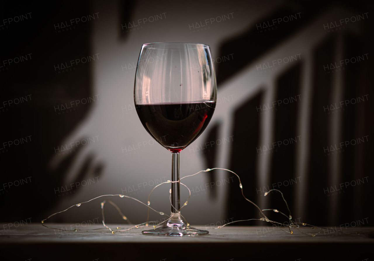 Glass of rich red wine with a warm, elegant ambiance.