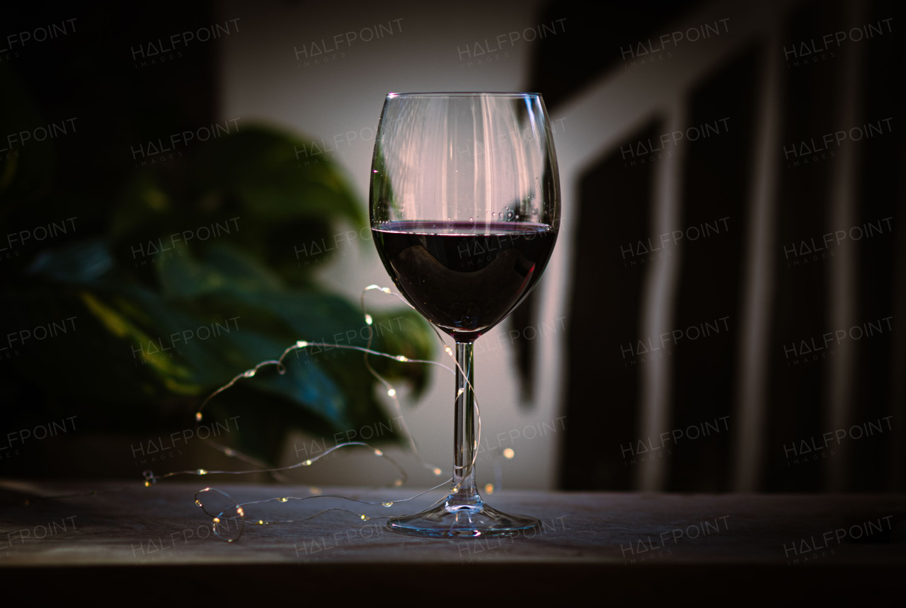 Glass of rich red wine with a warm, elegant ambiance.