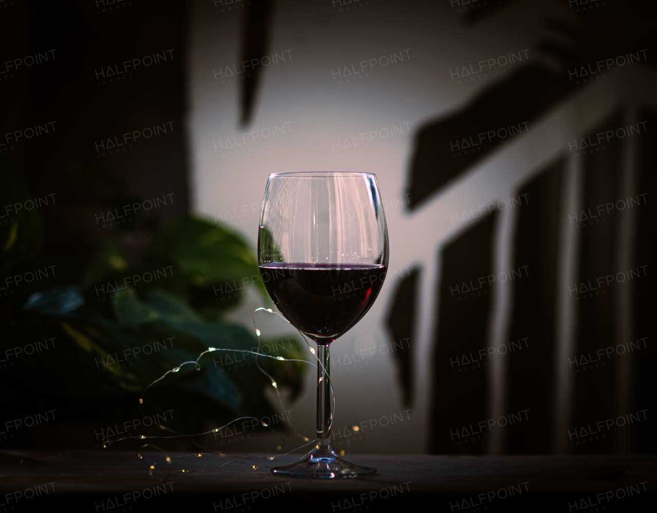 Glass of rich red wine with a warm, elegant ambiance.