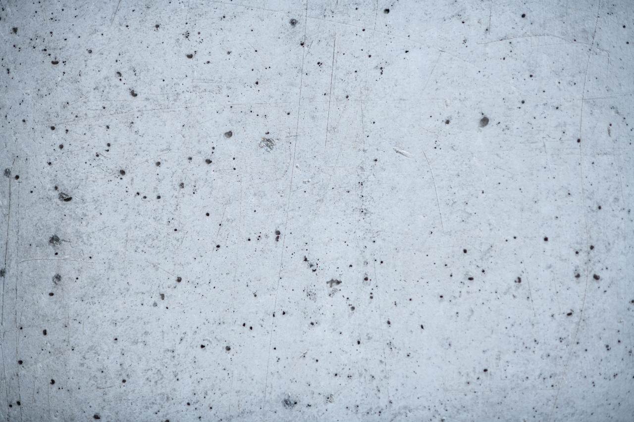 Concrete wall or surface with porous structure. Gray background.