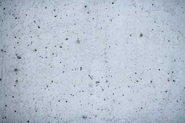 Concrete wall or surface with porous structure. Gray background.