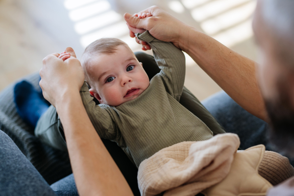 Portrait of a baby boy on his father's lap.