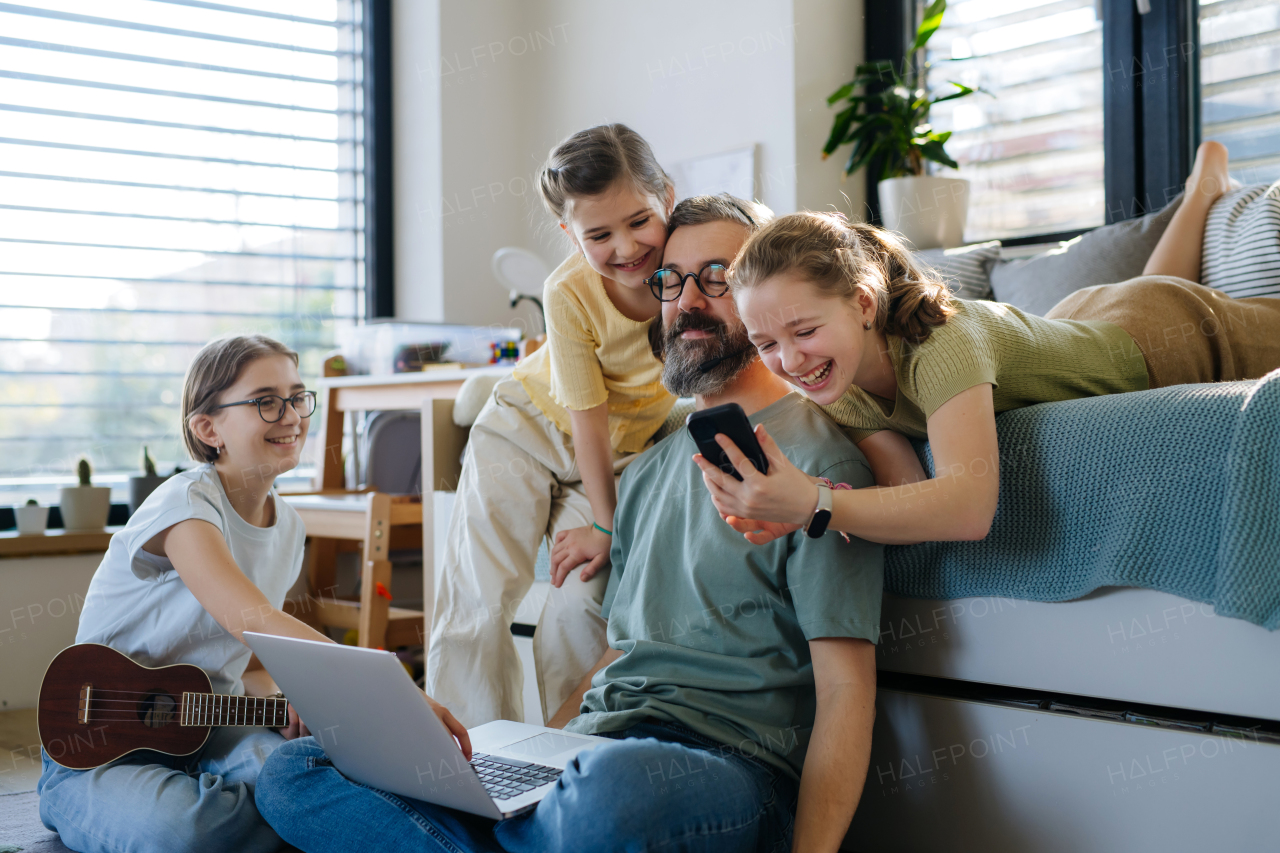 Father with three daughters trying to work from homeoffice. Girl dad concept.