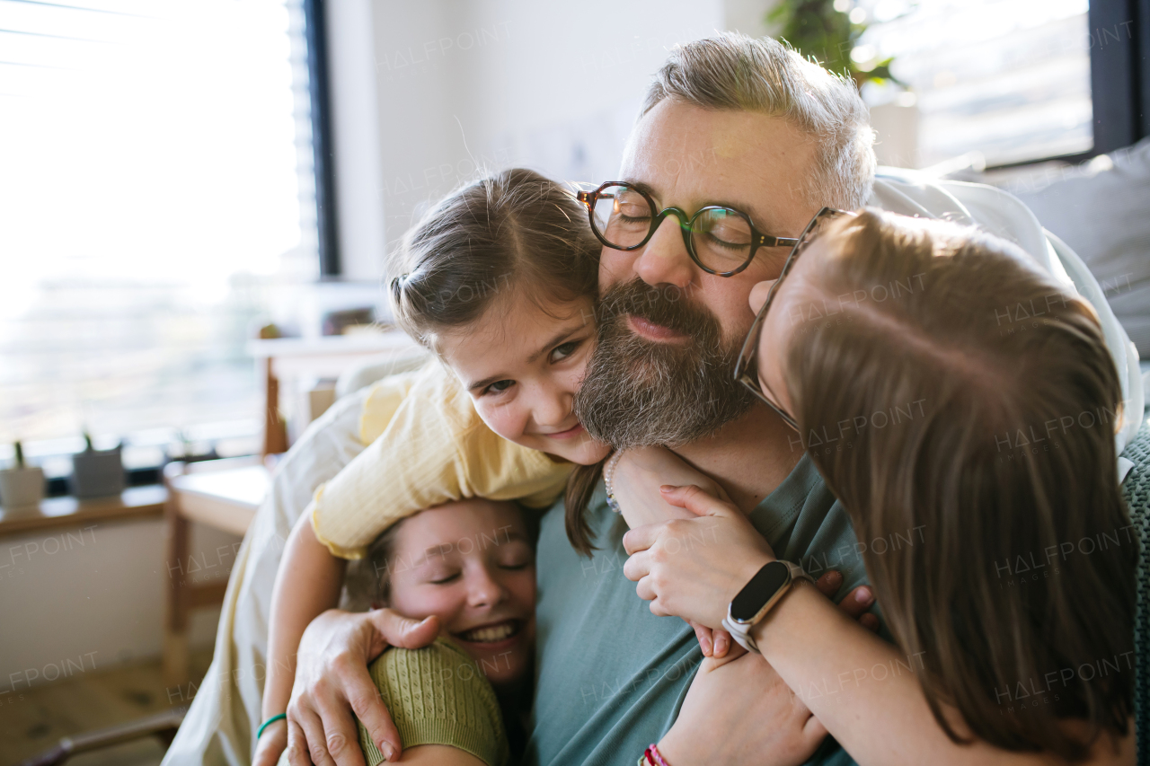 Portrait of father with three daughters at home. Girl dad concept.