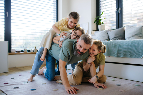 Portrait of father with three daughters at home. Girl dad concept.