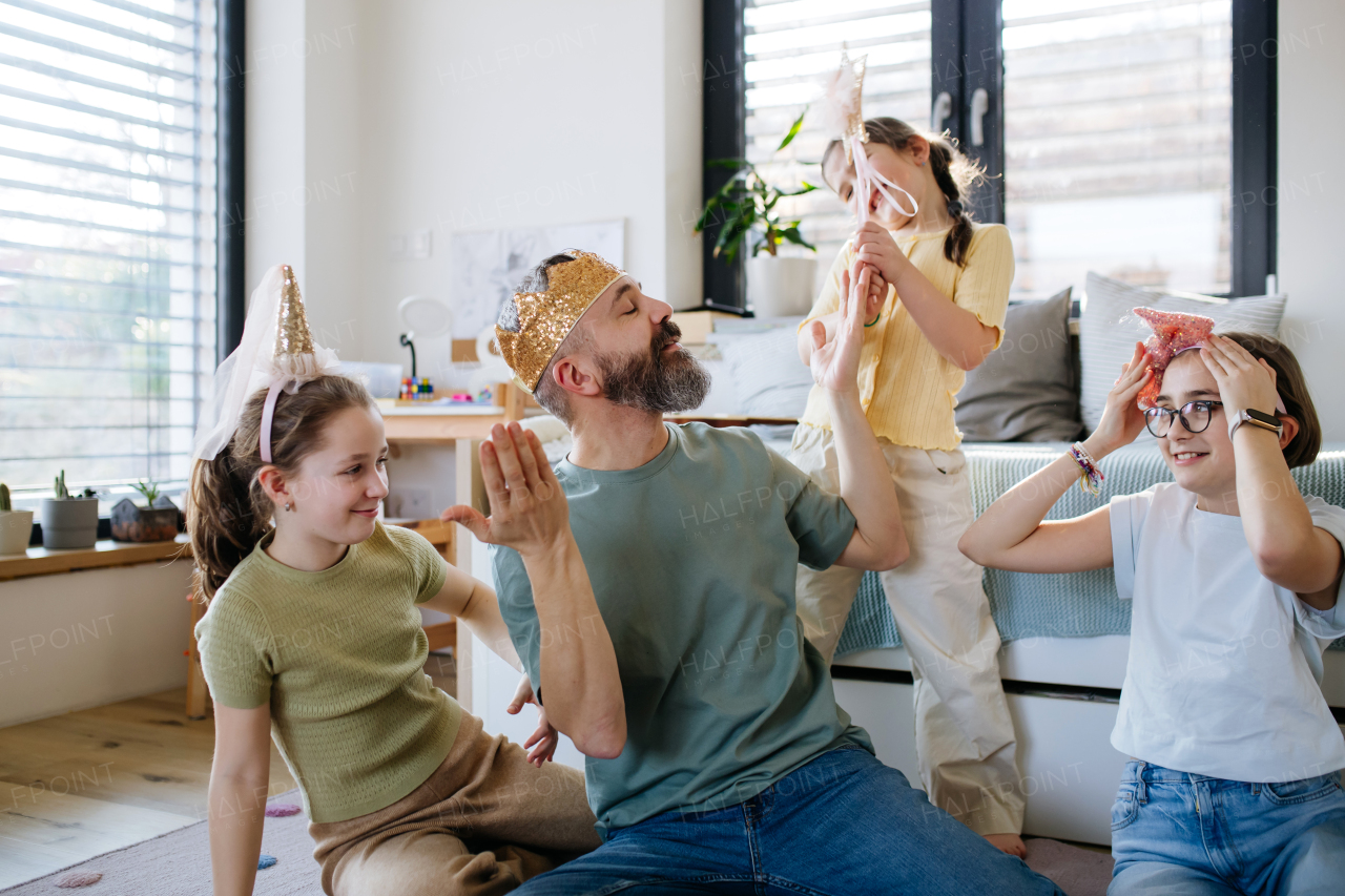 Portrait of father with three daughters at home. Girl dad concept.