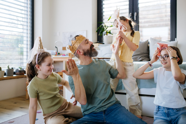 Portrait of father with three daughters at home. Girl dad concept.