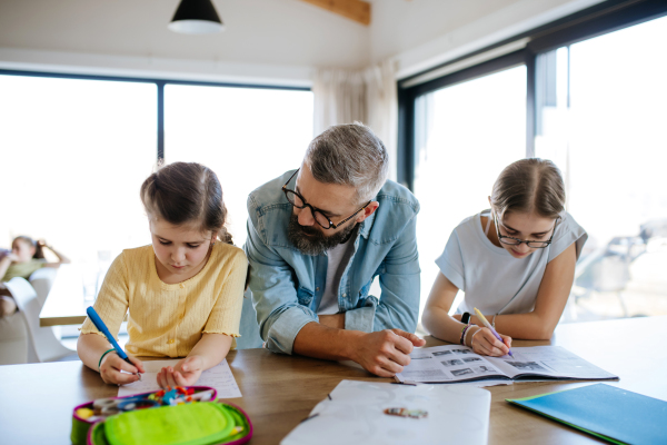 Father helping his daughters with their homework.