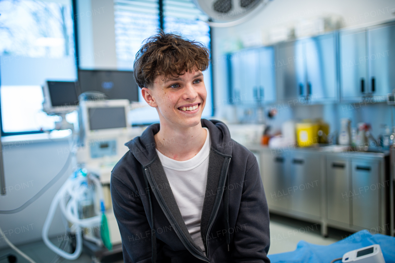 Teenage boy smiling during supportive medical consultation after receiving positive health news.
