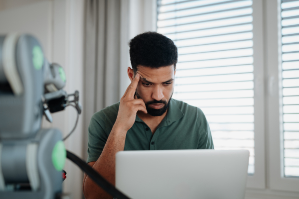 Engineer struggling with a technical problem while building robotic arm at home.