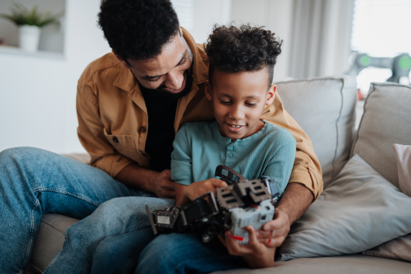 Father and son exploring STEM, robotics, and technology together at home