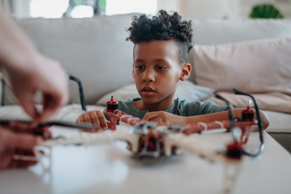 Father teaching son about STEM, robotics, and discussing technology at home.