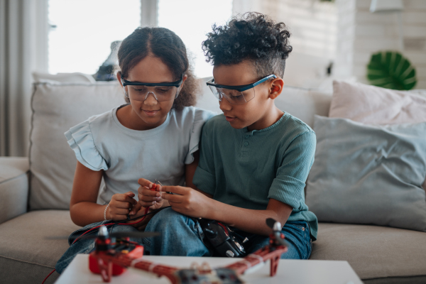 Kids building their first homemade robot at home. Educational robotic kit for children.