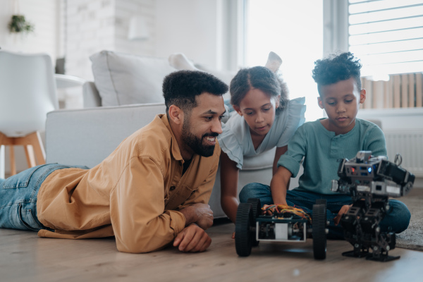 Father teaching kids about STEM, robotics, and discussing technology at home.