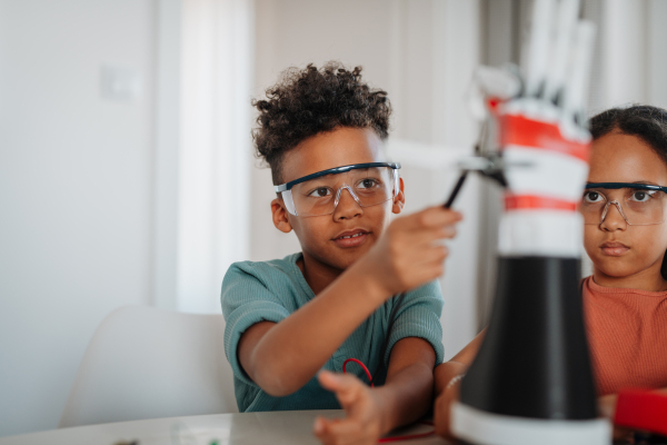 Kids building their first homemade robot at home. Educational robotic kit for children.
