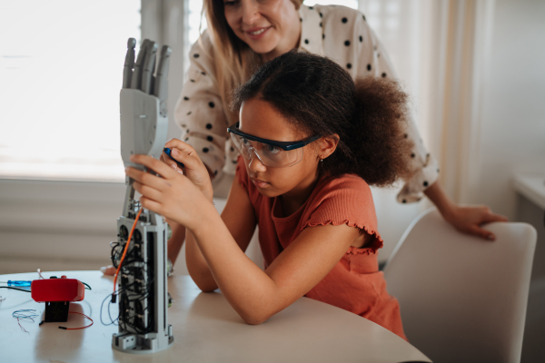 Mother teaching daughter robotics and inspiring interest in STEM.