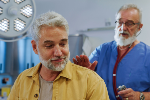 Doctor examining sick patient, listening to breathing with stethoscope.