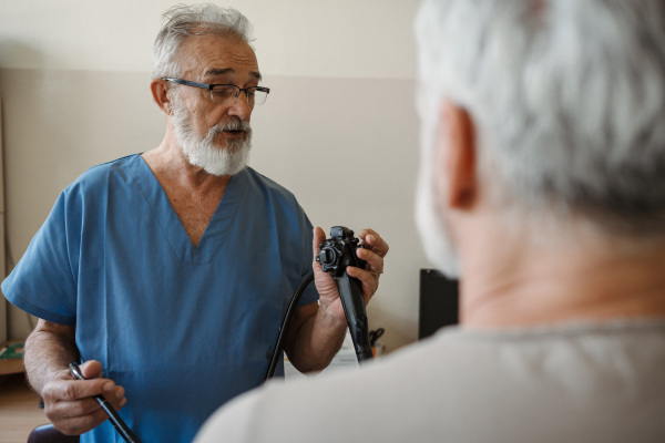 Doctor explaining gastroscopy procedure on patient. Examination of upper digestive tract. Medical procedure.