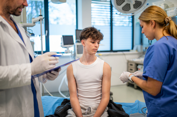 Teenage boy receiving vaccination during routine health checkup at hospital