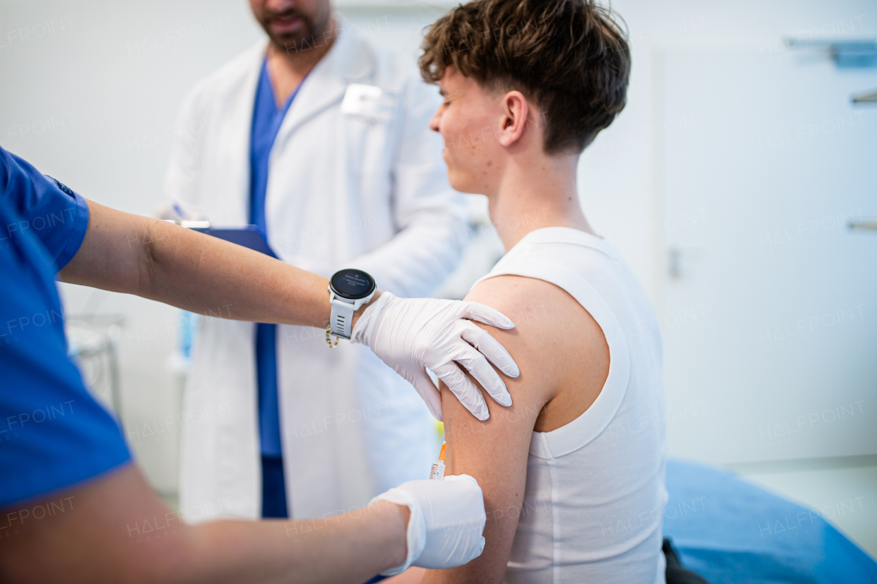 Teenage boy receiving vaccination during routine health checkup at hospital