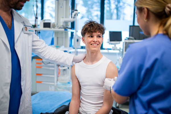 Teenage boy receiving vaccination during routine health checkup at hospital