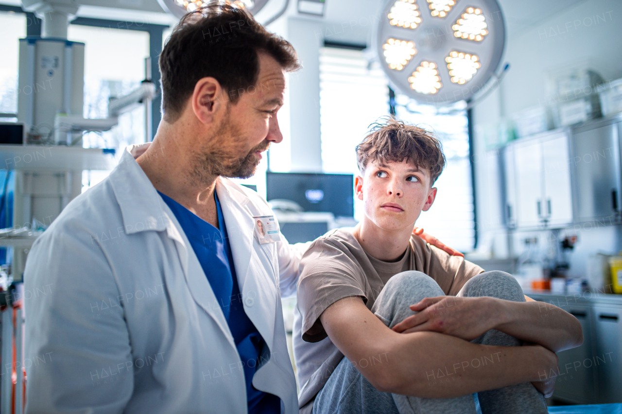 Teenager confiding in doctor about personal and health problems. Mental health evaluation for depressed teen boy.
