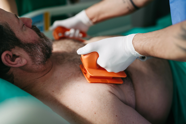 Emergency defibrillation on unconscious male patient in hospital.