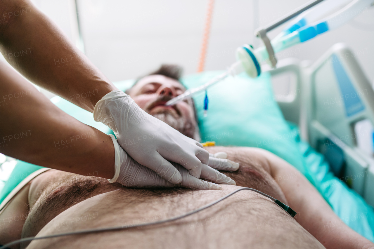 Close up of resuscitating unresponsive male patient in emergency room.