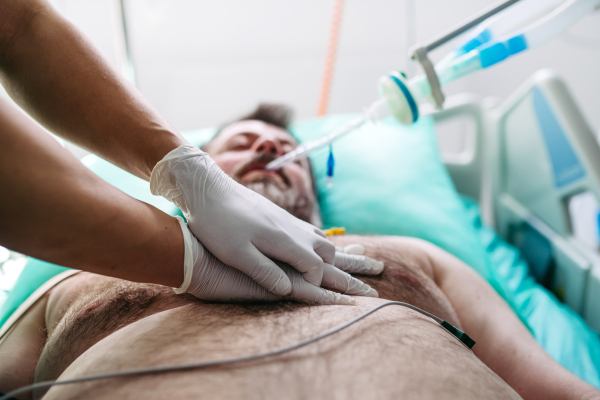 Close up of resuscitating unresponsive male patient in emergency room.