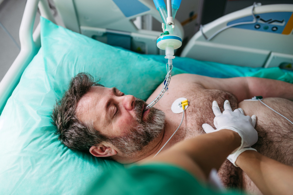 Close up of resuscitating unresponsive male patient in emergency room.