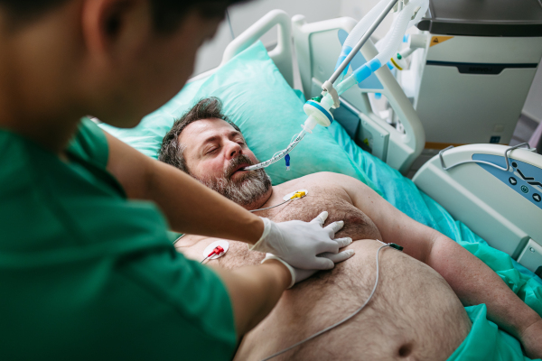 Medical team doing CPR on intubated patient in hospital.