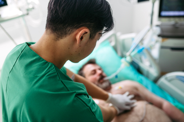 Medical team doing CPR on intubated patient in hospital.