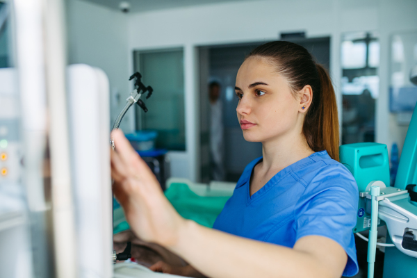 Nurse in emergency room, taking care of patient in ciritical condition.