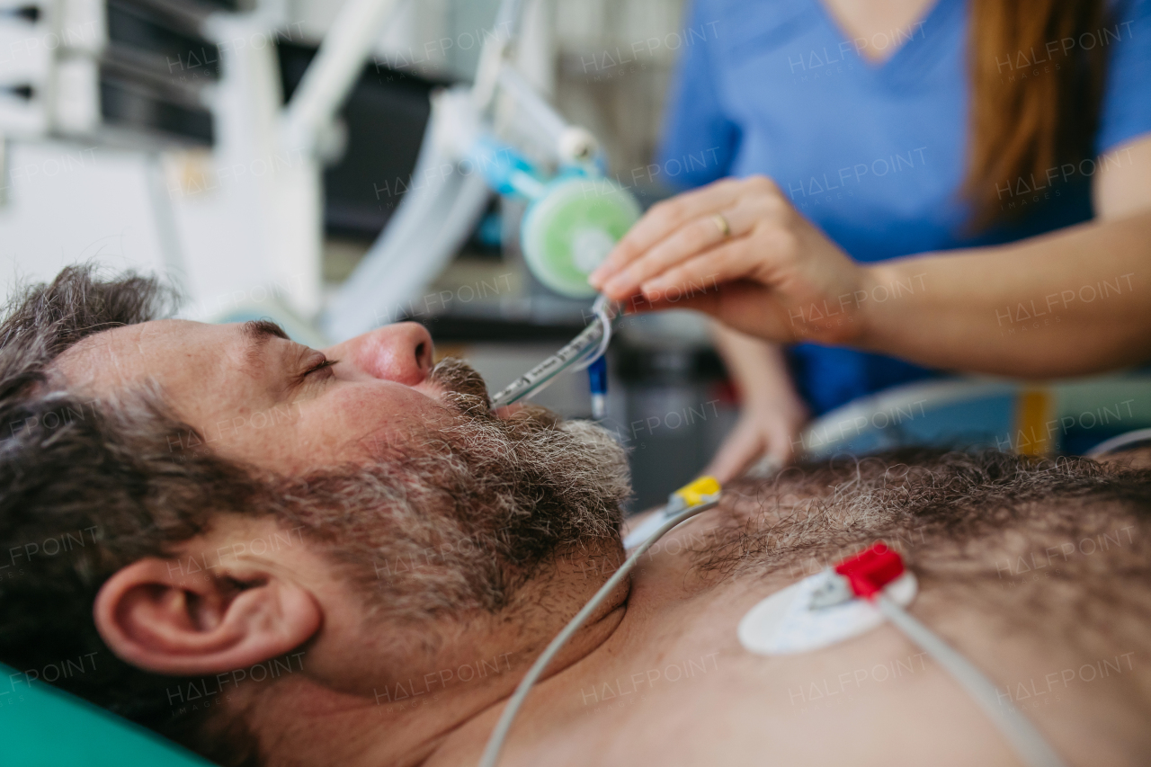 Nurse in emergency room, taking care of patient in ciritical condition.