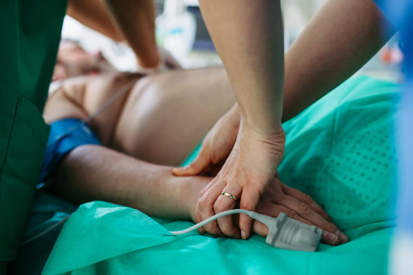 Medical team doing CPR on intubated patient in hospital.