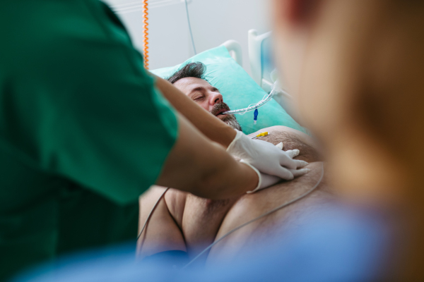 Medical team doing CPR on intubated patient in hospital.