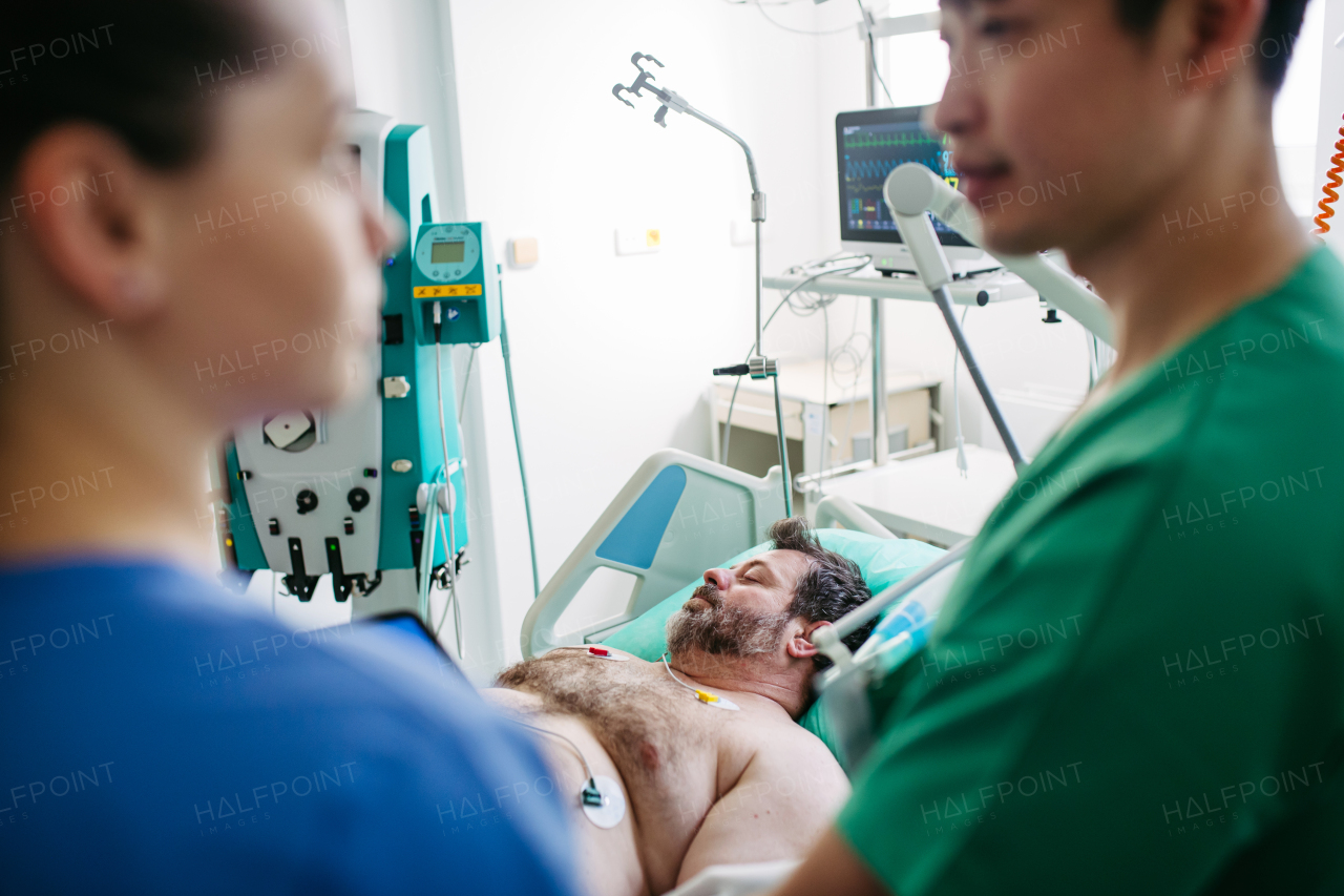 Doctors consulting, reviewing test results of critical patient in icu.