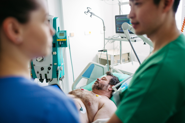 Doctors consulting, reviewing test results of critical patient in icu.