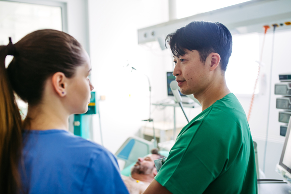 Doctors consulting, reviewing test results of critical patient in icu.