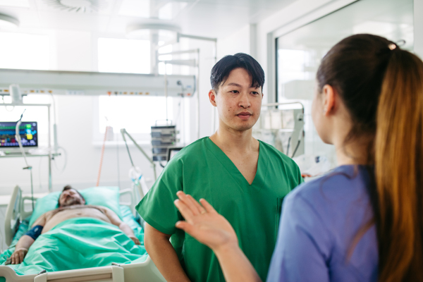 Doctors consulting, reviewing test results of critical patient in icu.