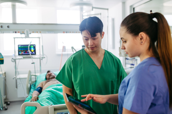 Doctors consulting, reviewing test results of critical patient in icu.