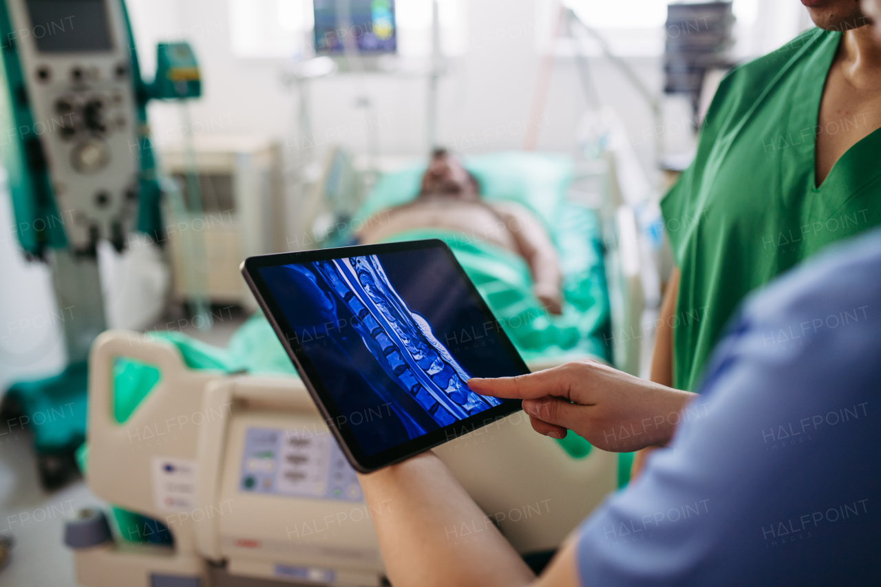 Doctors consulting, reviewing test results of critical patient in icu.