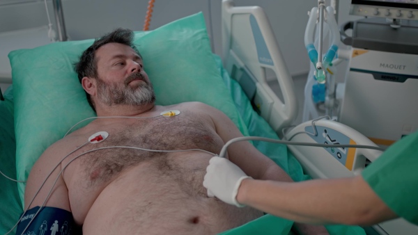 Medical professional using ultrasound probe in intensive care, abdominal ultrasound.