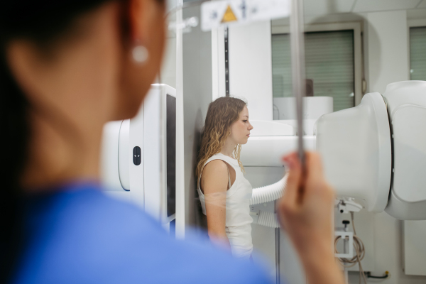 Young woman positioned on radiographic wall stand for diagnostic imaging