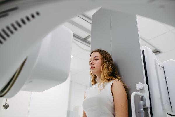 Young woman positioned on radiographic wall stand for diagnostic imaging