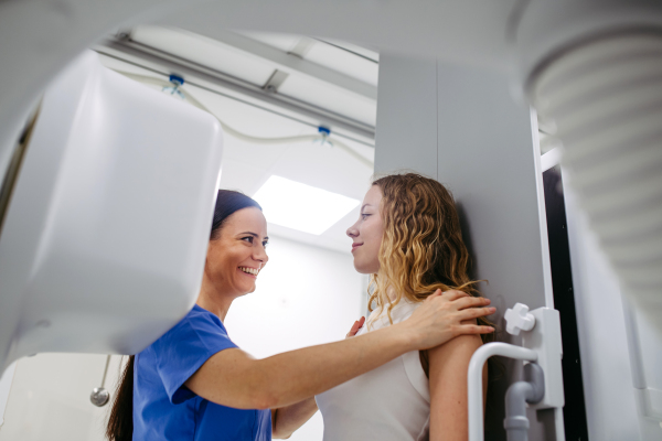 Young woman positioned on radiographic wall stand for diagnostic imaging