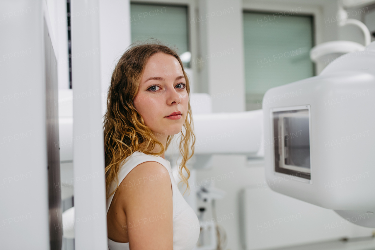 Woman positioned upright against wall stand for radiographic examination
