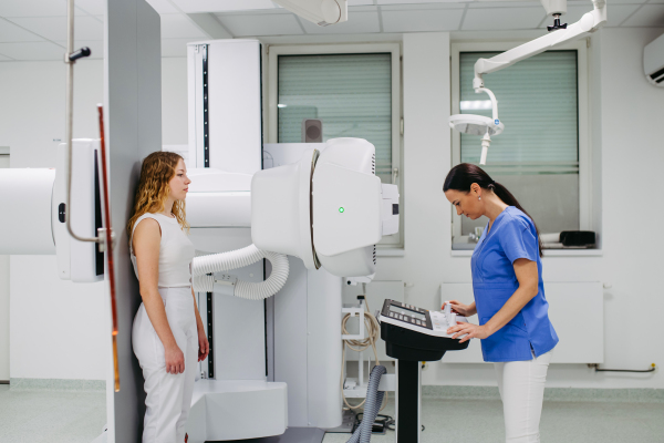 Young woman positioned on radiographic wall stand for diagnostic imaging