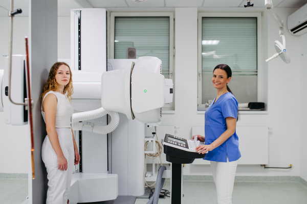 Young woman positioned on radiographic wall stand for diagnostic imaging
